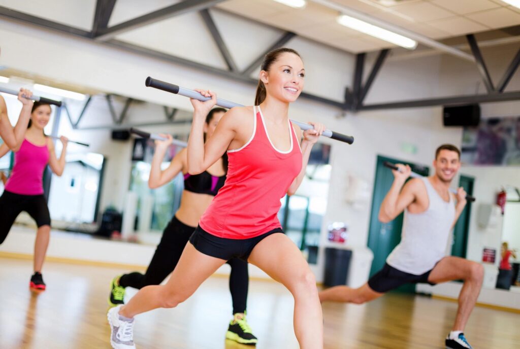 Woman leading a workout class doing lunges in a studio